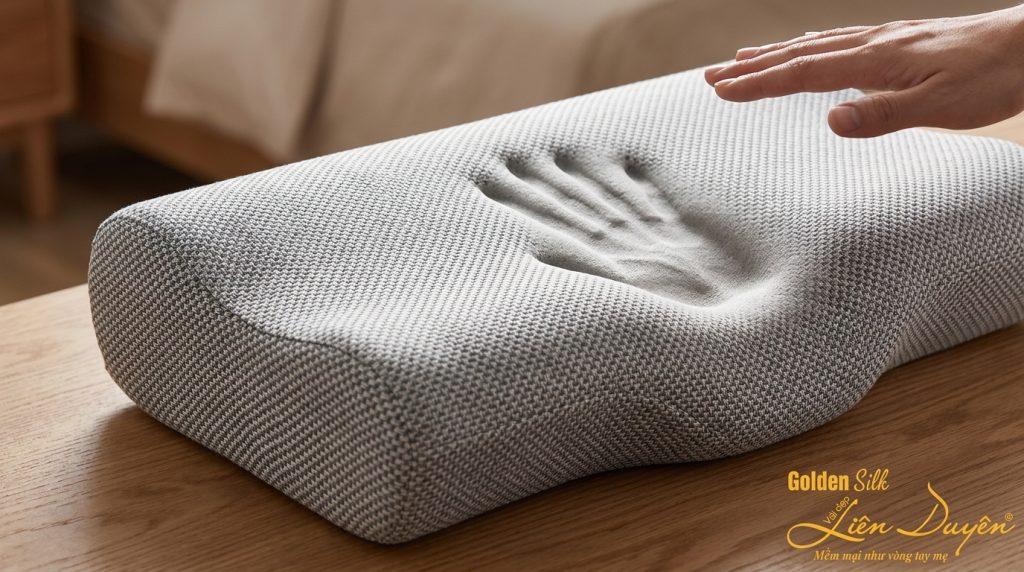 Gối Memory Foam với dấu ấn tay in lún, minh họa khả năng nhớ hình